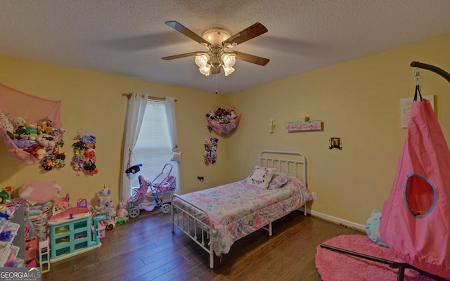 bedroom with ceiling fan, hardwood / wood-style flooring, and a textured ceiling