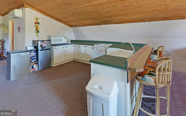 kitchen with wood ceiling, dark countertops, a sink, freestanding refrigerator, and dark colored carpet
