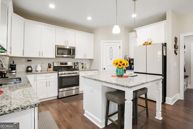 kitchen with decorative backsplash, appliances with stainless steel finishes, and dark wood-style floors