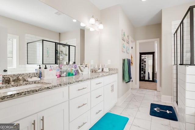 bathroom with a sink, a stall shower, double vanity, and marble finish floor