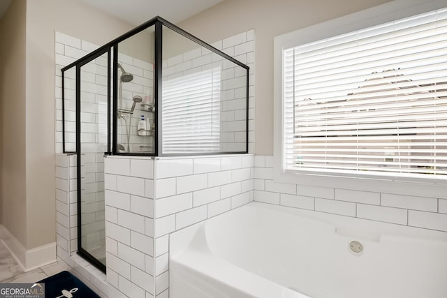 full bathroom with a garden tub, marble finish floor, baseboards, and a shower stall