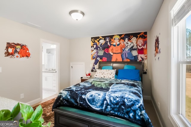 bedroom with baseboards, multiple windows, and ensuite bath