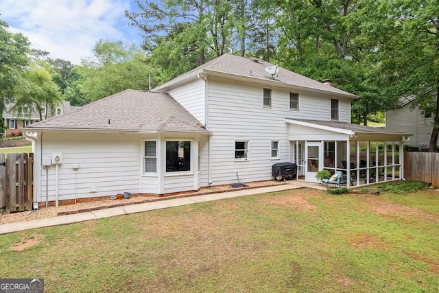 back of property featuring a sunroom, fence, a yard, a patio, and a shingled roof