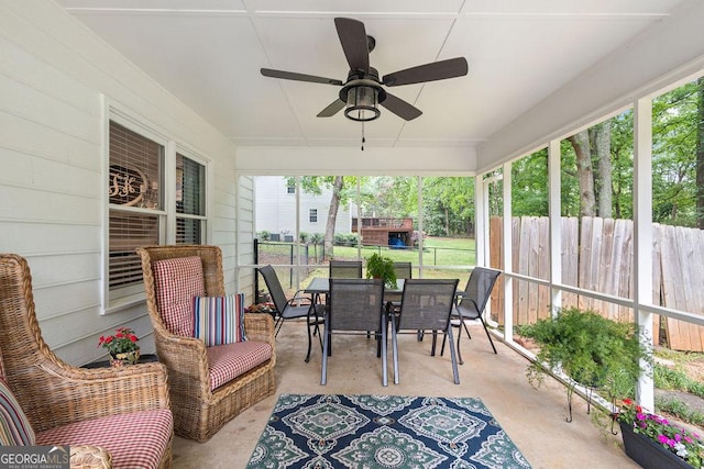 sunroom / solarium featuring outdoor dining area and ceiling fan