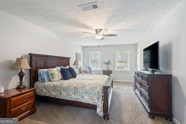 bedroom featuring visible vents, baseboards, ceiling fan, a textured ceiling, and carpet flooring