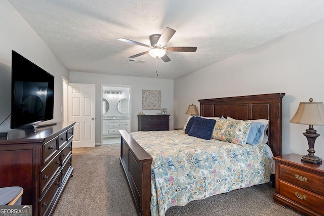 bedroom with visible vents, a ceiling fan, a textured ceiling, carpet flooring, and ensuite bath