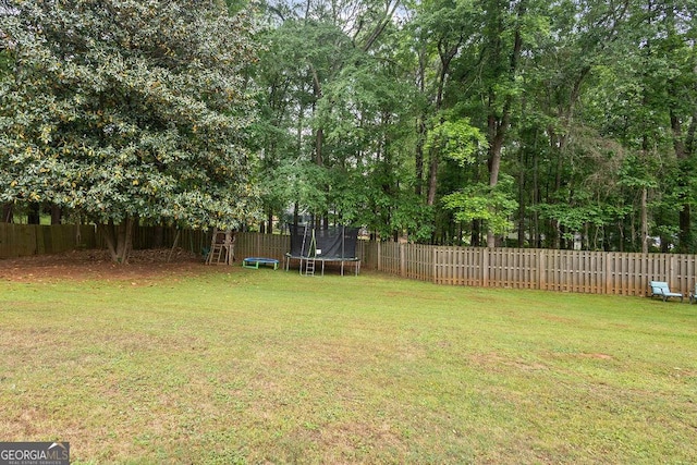 view of yard featuring a fenced backyard and a trampoline