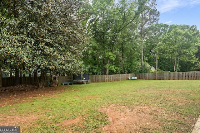 view of yard with a fenced backyard and a trampoline
