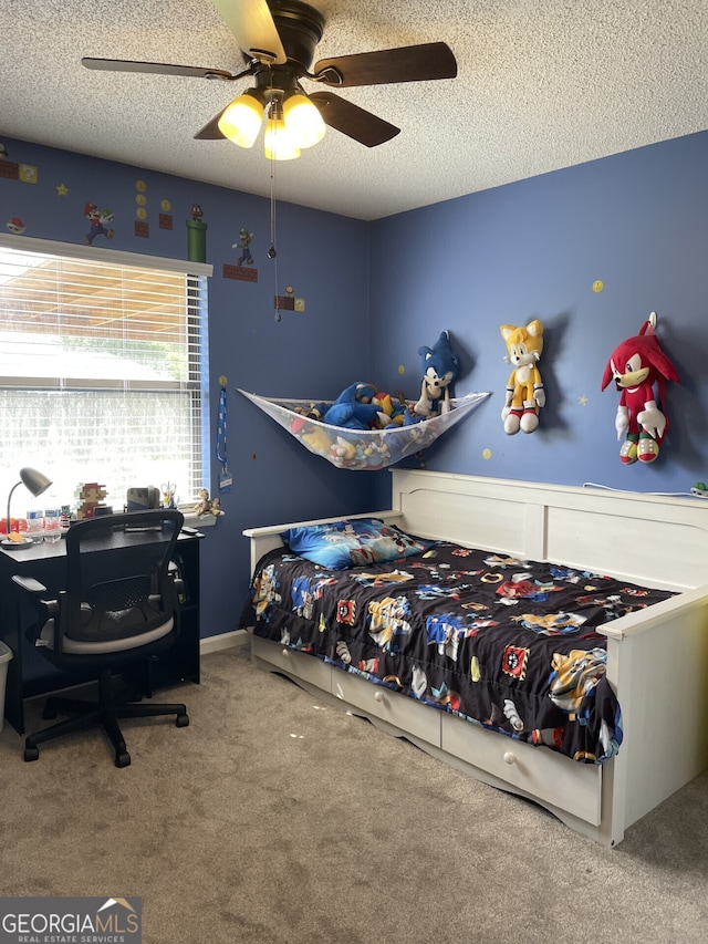 carpeted bedroom featuring ceiling fan and a textured ceiling