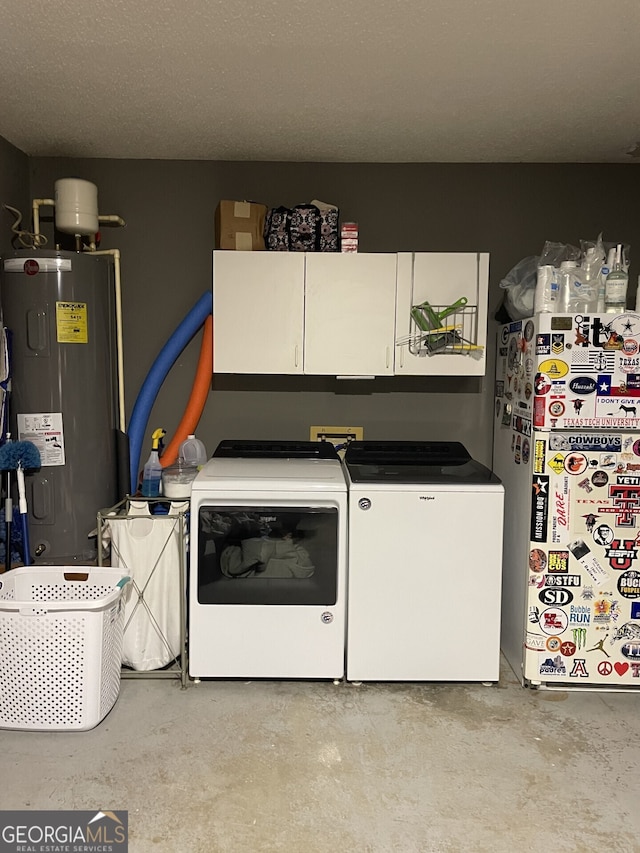 washroom featuring cabinet space, water heater, and washer and dryer