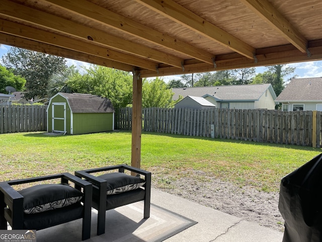 view of yard featuring an outdoor structure, a fenced backyard, a patio area, and a storage shed