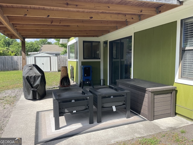 view of patio / terrace featuring fence, an outbuilding, and a storage shed