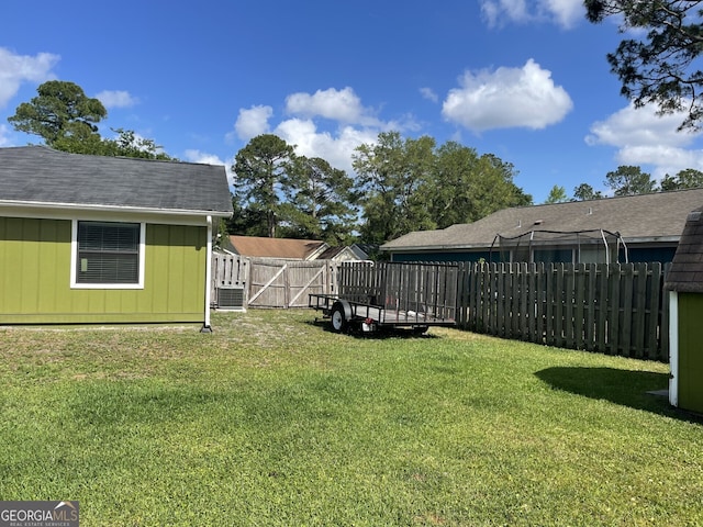 view of yard with a fenced backyard and central AC unit
