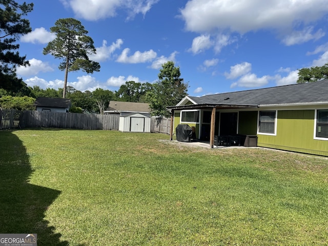 view of yard with a fenced backyard, a patio, an outbuilding, and a shed