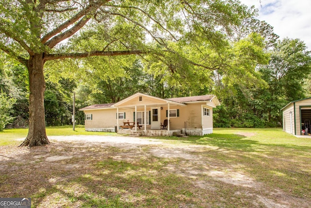 back of property with a porch and a yard