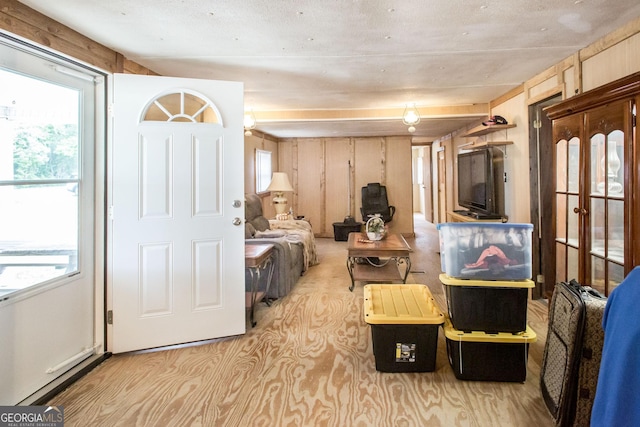 living room featuring wooden walls and light carpet