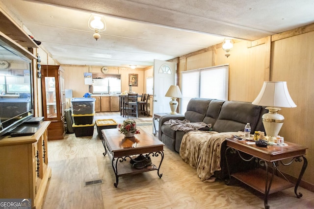 living room with visible vents, plenty of natural light, and light wood-style flooring