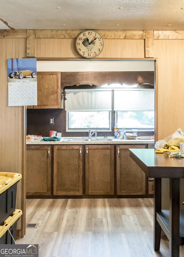kitchen featuring a sink, light wood-style flooring, and a textured ceiling