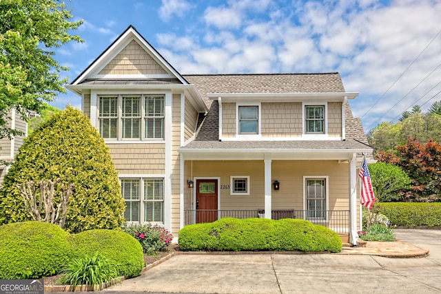 view of front of home featuring roof with shingles and covered porch