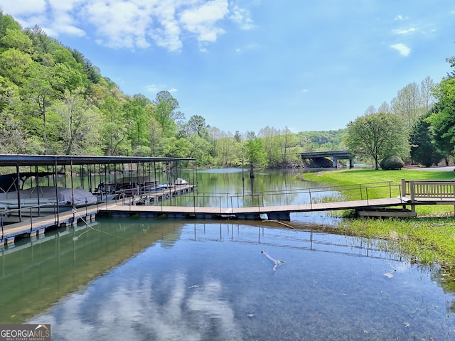 dock area featuring a water view and a wooded view
