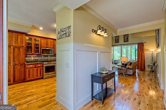 kitchen with crown molding, appliances with stainless steel finishes, and dark countertops