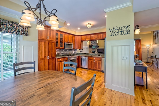 kitchen featuring brown cabinetry, crown molding, dark countertops, tasteful backsplash, and stainless steel appliances