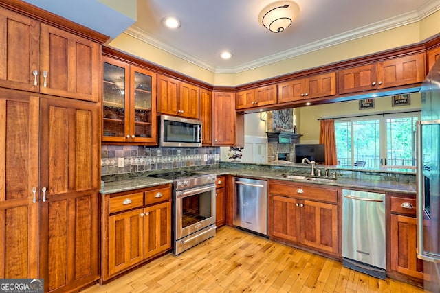 kitchen with crown molding, decorative backsplash, brown cabinetry, and stainless steel appliances