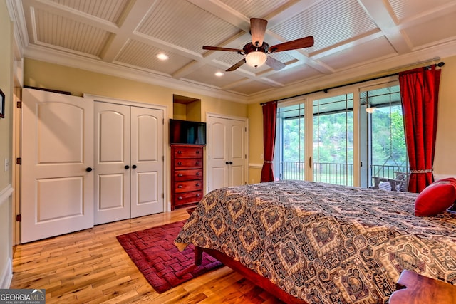 bedroom featuring two closets, access to exterior, light wood finished floors, and coffered ceiling