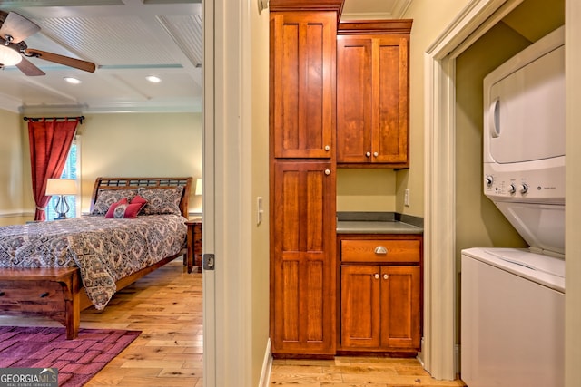 interior space featuring light wood-type flooring, ornamental molding, stacked washing maching and dryer, and recessed lighting