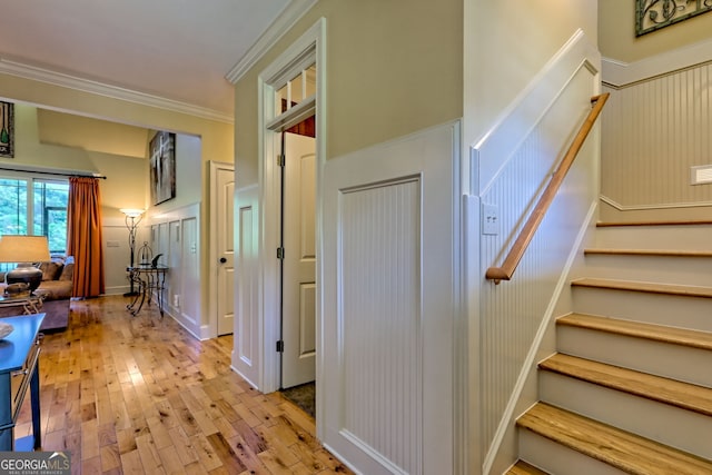 stairs featuring ornamental molding and hardwood / wood-style flooring