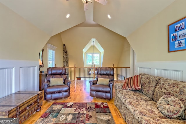 living room with plenty of natural light, ceiling fan, wood finished floors, and vaulted ceiling