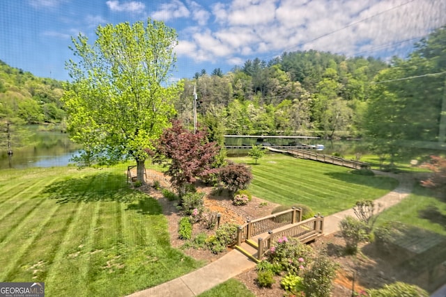 view of yard with a water view and a wooded view