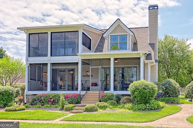 exterior space featuring a sunroom, a chimney, and stairway