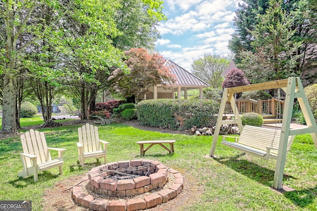 view of yard with a playground, ceiling fan, and a fire pit
