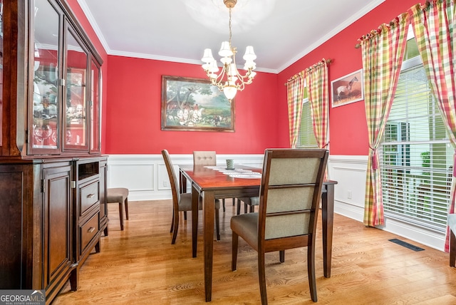 147 S Pine Cove Dr, Lagrange, GA 30240 - dining room featuring a chandelier, crown molding, light wood-style flooring, wainscoting, and a decorative wall