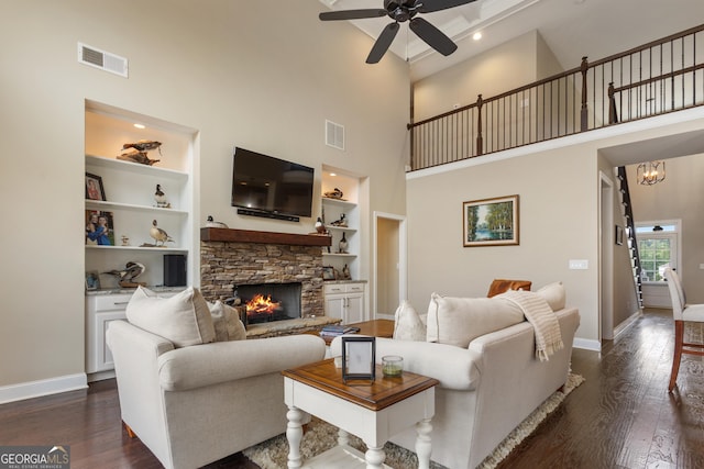 living area featuring visible vents, baseboards, ceiling fan with notable chandelier, and dark wood finished floors