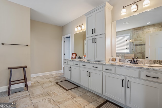 full bathroom with baseboards, tiled shower, a sink, and marble finish floor