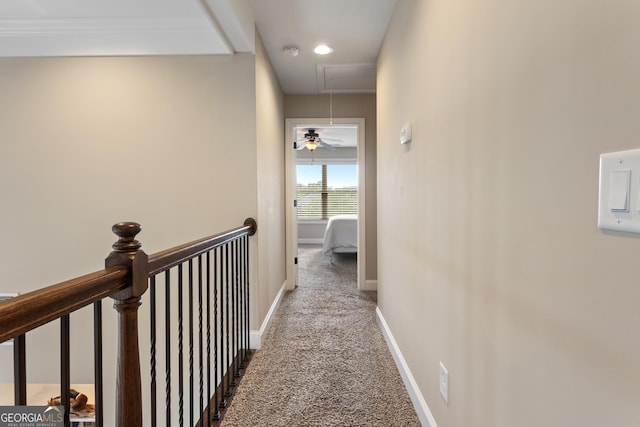 corridor with carpet floors, attic access, baseboards, and an upstairs landing