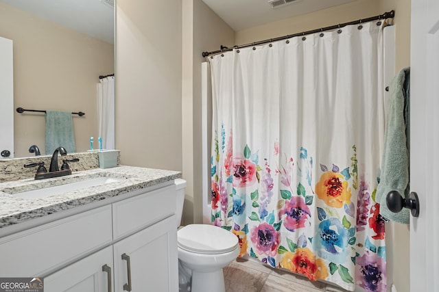 bathroom featuring vanity, a shower with shower curtain, toilet, and visible vents