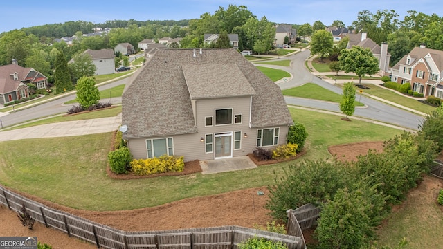 rear view of property with a residential view, a lawn, and roof with shingles