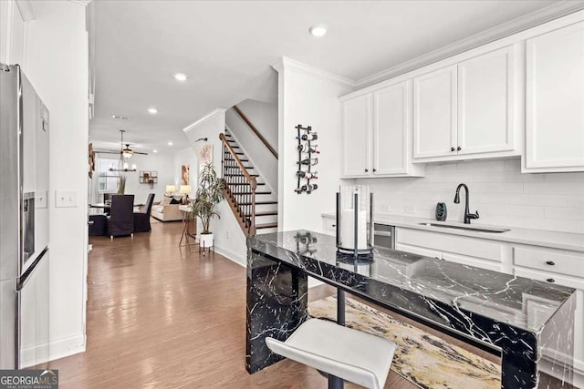 2669 Caruso Way, Atlanta, GA 30339 - kitchen featuring a sink, white cabinets, backsplash, and light wood-type flooring