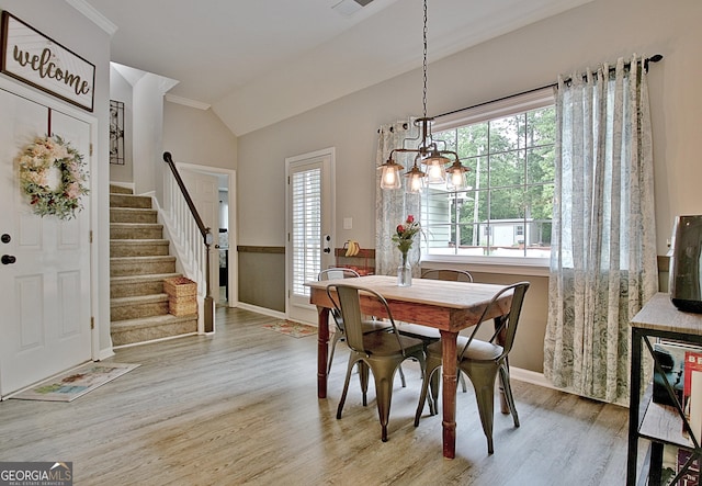 dining space with crown molding, vaulted ceiling, wood finished floors, stairway, and baseboards