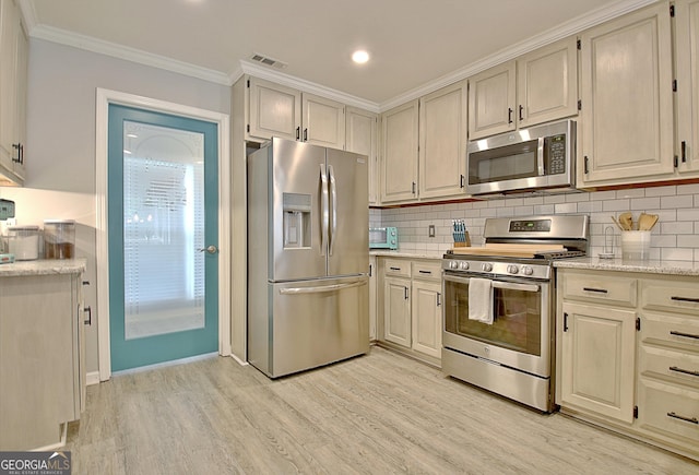 kitchen featuring visible vents, tasteful backsplash, ornamental molding, stainless steel appliances, and light wood-style flooring