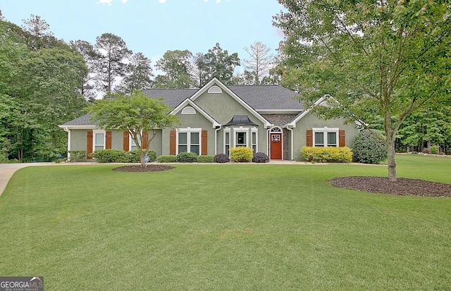 view of front of property featuring roof with shingles, stucco siding, and a front lawn
