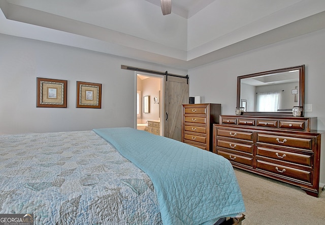 bedroom with carpet flooring, a ceiling fan, a barn door, and connected bathroom