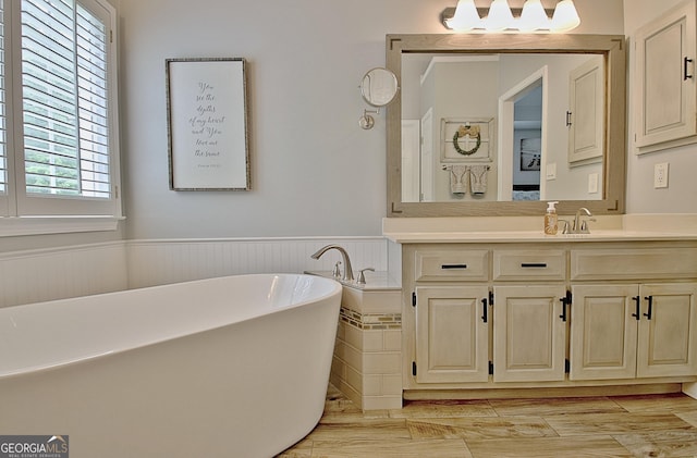 bathroom featuring vanity, wainscoting, and a freestanding bath