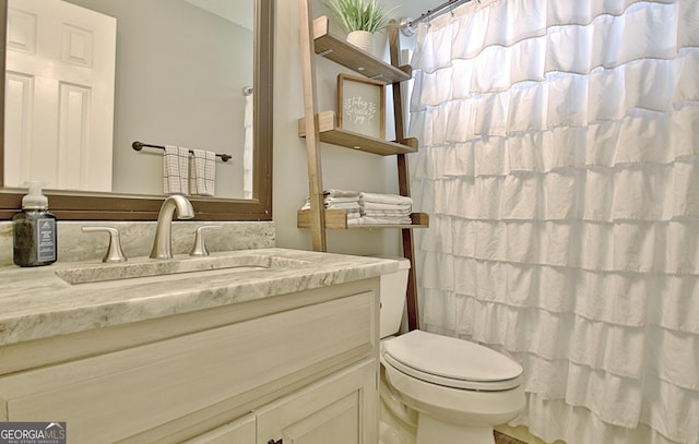 bathroom featuring toilet, a shower with shower curtain, and vanity