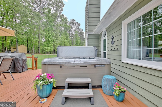 deck with an outdoor structure, a hot tub, a grill, and a shed