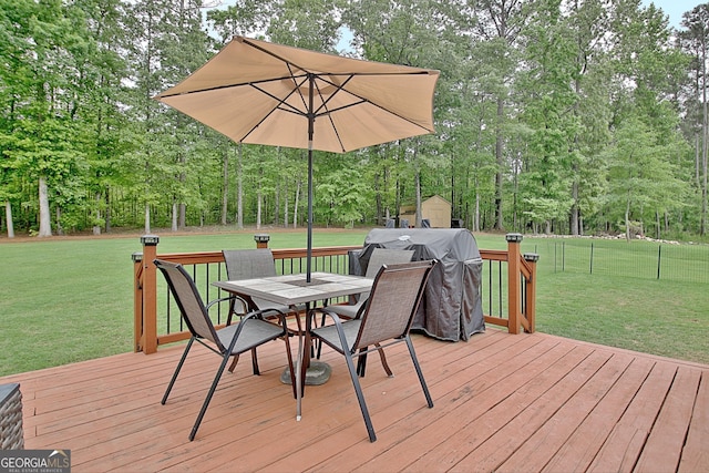 wooden deck featuring a lawn, an outdoor structure, outdoor dining space, and a shed