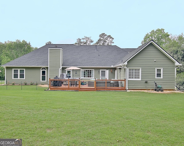 rear view of property featuring a wooden deck and a yard